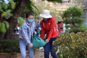 Giáo viên Trường Mầm non Nhân Trạch (Bố Trạch - Quảng Bình) chuyển những bao tải cát để đưa lên mái nhà chèn tấm lợp để tránh bị tốc mái.