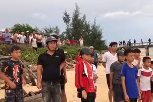 Người dân đứng chờ tàu đưa thi thể anh Khoa vào bờ (Ảnh cắt từ clip).