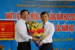 Ông Vũ Đại Thắng (phải) tặng hoa nhân ngày khai giảng năm học mới cho lãnh đạo Trường THPT Chuyên Võ Nguyên Giáp.