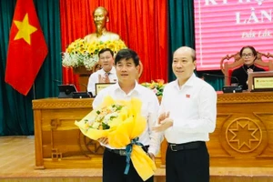 Ông Phạm Ngọc Nghị - Chủ tịch UBND tỉnh Đắk Lắk tặng hoa chúc mừng ông Nguyễn Thiên Văn (ảnh: CL).