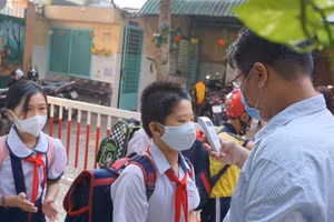 Học sinh Trường TH Trần Quang Khải, Quận Gò Vấp được kiểm tra thân nhiệt trước khi vào trường. Ảnh minh hoạ 