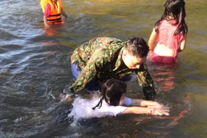 Chiến sĩ Đồn Biên phòng cửa khẩu Thanh Thủy (BĐBP Nghệ An) hướng dẫn học sinh tập bơi. Ảnh: Đồn BP cung cấp