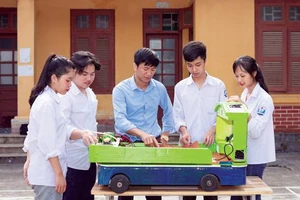 Thầy Nguyễn Trung Kiên hướng dẫn học sinh thực hiện dự án “Hệ thống kiểm tra, báo hiệu và ngăn chặn những nguy cơ làm mất an toàn giao thông do nồng độ cồn của tài xế và sự thiếu kiểm soát số người trên xe ô tô”. Ảnh: NVCC