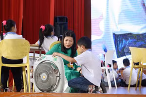 Cô Mai hướng dẫn học trò các bước sử dụng quạt điện an toàn.