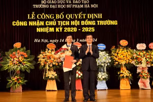 Thứ trưởng Bộ GD&ĐT Nguyễn Văn Phúc (bên phải) trao quyết định và tặng hoa chúc mừng tân Chủ tịch Hội đồng Trường ĐH Sư phạm Hà Nội.