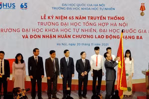 Thứ trưởng Hoàng Minh Sơn thừa ủy quyền của Chủ tịch nước gắn Huân chương Lao động hạng Ba lên lá cờ truyền thống của Trường ĐH Khoa học Tự nhiên, ĐHQG Hà Nội.