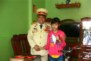 Một em nhỏ được ông Tự trao xe đạp và quà trong chương trình khuyến học.