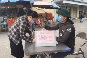 Người dân khai báo y tế tại lối vào chợ Hạ Long.