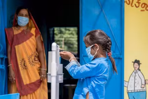 Học sinh Ấn Độ sát khuẩn tay trước khi vào trường học.