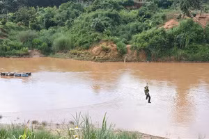 Người dân tiếp tục đu cáp vượt sông Pô Kô trong thời gian chờ đợi cây cầu treo hoàn thiện.