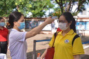 Thí sinh đo thân nhiệt, thực hiện giãn cách bảo đảm an toàn phòng dịch.