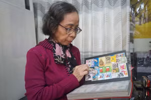 Bà Nguyễn Thị Kim Thanh bên bộ sưu tập tem của mình.