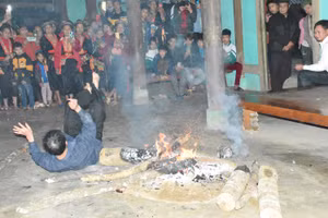 Người nhà thực hiện việc nhảy lửa để cầu mong may mắn, tốt lành.