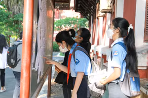 Thí sinh xem danh sách phòng thi tại điểm thi Trường THPT chuyên Quốc học Huế. (Ảnh: Hoàng Hải)