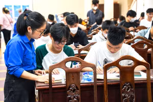 Tình nguyện viên hướng dẫn thí sinh điền thông tin vào hồ sơ nhập học.