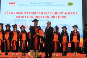 GS.TS Nguyễn Công Nghiệp, Phó Hiệu trưởng Thường trực nhà trường trao bằng tốt nghiệp cho các tân cử nhân. 