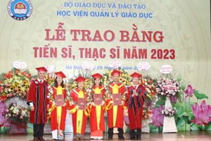 GS.TS Phạm Quang Trung, Giám đốc Học viện Quản lý giáo dục (ngoài cùng bên phải) và PGS.TS Trần Hữu Hoan, Phó Giám đốc Học viện (ngoài cùng bên trái) trao bằng tốt nghiệp cho các tân tiến sĩ.