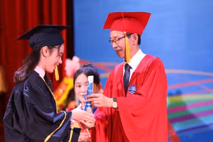 GS.TS Nguyễn Văn Minh - Hiệu trưởng Trường ĐH Sư phạm Hà Nội trao chúc thư và tặng hoa chúc mừng cho các tân cử nhân - sáng 9/6.