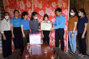 Lãnh đạo LĐLĐ tỉnh Quảng Bình trao tiền hỗ trợ cho cháu Trần Hà Vy, xã Kim Hóa, huyện Tuyên Hóa. 