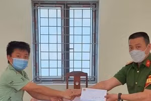 Anh Mùa A Khua - bố cháu Trang bàn giao số tiền cho Công an xã Xà Hồ.