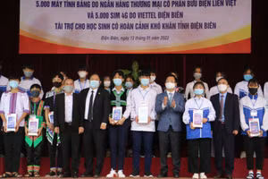 Đại diện lãnh đạo tỉnh Điện Biên và nhà tài trợ trao máy tính bảng cho học sinh khó khăn. 