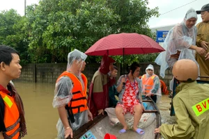 Công an đưa thai phụ lên ghe vượt lũ đến bệnh viện sinh. (Ảnh: CACC)