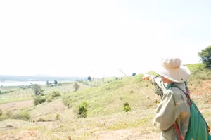 Ông A Mít chỉ về nơi phát hiện dấu tích của cha ông trước khi di chỉ ngày nào bị chìm vào quên lãng.