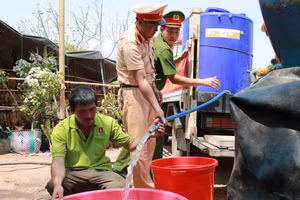 Lực lượng Công an Ea Súp tiếp nước cho hộ ông Lò Văn Kiều. (Ảnh: Thành Tâm)