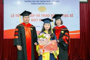 TS Trần Thanh Nhàn (phải) cùng đại diện khoa QTKD trao bằng tốt nghiệp cho các tân thạc sĩ