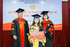 TS Trần Thanh Nhàn (phải) cùng đại diện khoa QTKD trao bằng tốt nghiệp cho các tân thạc sĩ