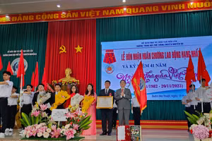 Ông Nguyễn Đình Trung trao Huân chương Lao động hạng Nhất cho tập thể Nhà trường. (Ảnh: TT)