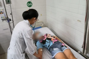 Bác sĩ đang thăm khám cho một trong số những học sinh nhập Bệnh viện Lê Văn Thịnh điều trị nghi do ngộ độc thực phẩm. 