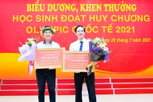 Thầy giáo Lê Xuân Đại, Trường THPT Chuyên Vĩnh Phúc và em Vũ Ngọc Bình (bìa trái) được UBND tỉnh Vĩnh Phúc khen thưởng.