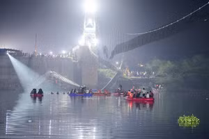 Nhân viên cứu hộ Ấn Độ tiến hành các hoạt động tìm kiếm sau khi một cây cầu bắc qua sông Machchhu bị sập ở Morbi.