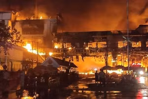 Lính cứu hỏa chiến đấu với ngọn lửa tại khách sạn-sòng bạc Grand Diamond City ở Poipet, Campuchia, hôm 29/12. Ảnh: AFP.