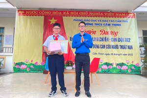 Em Hoàng Mạnh Chiến (trái) được nhà trường tuyên dương, khen thưởng ngay tại trường vào chiều 28/11. Ảnh: TG.