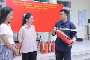 Cán bộ Cảnh sát PCCC&CNCH - Công an huyện Hoài Đức hướng dẫn người dân cách sử dụng phương tiện chữa cháy tại chỗ. Ảnh: Đình Tuệ.