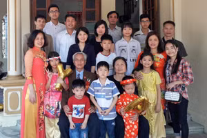 Vợ chồng nhà giáo Bùi Khắc Thái vui vầy bên con cháu. Ảnh: Lường Toán