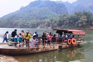 Học sinh và người dân làng Bèo Bọt qua sông Mã trên chiếc đò ngang.