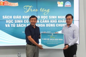 Ông Trần Nguyễn Minh Thành, Phó Giám đốc Sở GD&ĐT Đà Nẵng (bên phải) tiếp nhận sách giáo khoa từ chương trình Cùng tiếp bước em tới trường. 