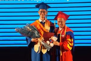 Nguyễn Hoàng Gia Khánh (trái) nhận bằng tốt nghiệp từ tay GS.TS Huỳnh Văn Sơn. Ảnh: Mạnh Tùng