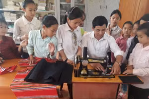 Thầy Nguyễn Văn Hùng, Phòng GD&ĐT huyện Than Uyên (Lai Châu) hướng dẫn học sinh CLB Khâu thêu, bảo tồn, phát huy bản sắc văn hóa của các dân tộc, gắn liền với nhiệm vụ giáo dục dân tộc. Ảnh: NVCC