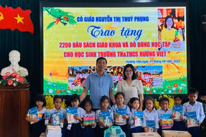 Cô giáo Nguyễn Thị Thúy Phụng tặng sách giáo khoa mới cho học sinh. 