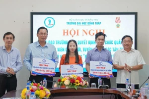 TS Trương Tấn Đạt - Chủ tịch Hội đồng trường (trái) và TS Hồ Văn Thống - Hiệu trưởng Trường ĐH Đồng Tháp trao hỗ trợ viên chức tuyển dụng mới có học vị tiến sĩ. Ảnh: NTCC