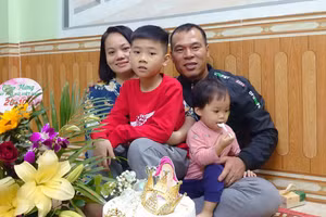 Cô Lê Thị Ngà cùng chồng con. Ảnh: Lan Anh