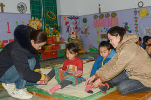 Giáo viên điểm Nậm Ty 2, Trường Mầm non Hua Thanh hướng dẫn học sinh đi tất giữ ấm.