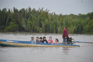 Học sinh điểm Trường Tiểu học Tân Tiến (xã Tân Tiến, huyện Đầm Dơi, Cà Mau) đến trường bằng xuồng. Ảnh: V. Hữu