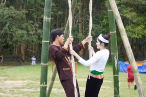 Chàng trai, cô gái Mường cùng chơi đu quay.