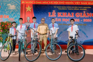 Ông Hòa (đứng giữa) tặng xe cho học sinh Trường THCS Trần Hưng Đạo.