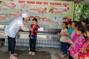 Nhân viên y tế Trường PTDTBT Tiểu học Trung Thu, huyện Tủa Chùa hướng dẫn học sinh rửa tay bằng xà phòng.